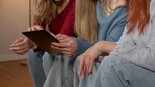 Young Women Using Tablet Together Indoors
