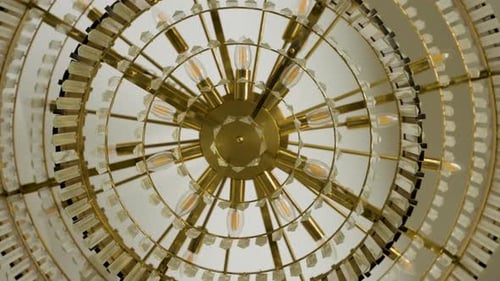 Luxuriöser Kronleuchter mit goldenen Stufen und Kristalldetails, die von der Decke hängen