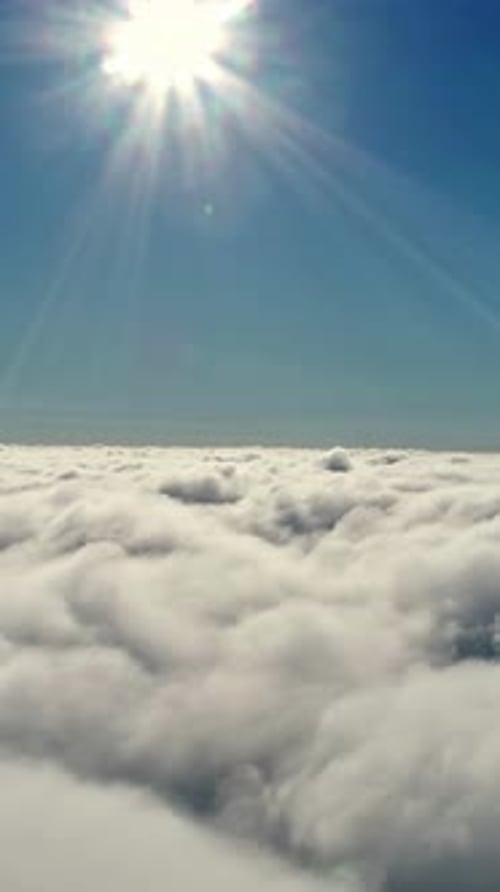Soleil brillant brillant sur les nuages duveteux en vue aérienne pendant la journée avec un ciel bleu