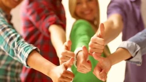 Enthusiastic Young People Giving Thumbs Up Together