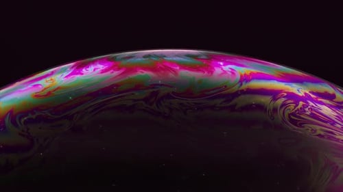 Concept abstrait L'iris multicolore d'une bulle de savon est en mouvement : bulle arc-en-ciel sur fond noir