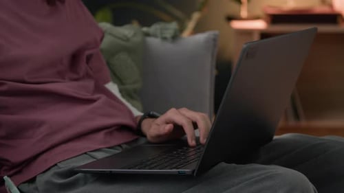 Man Works on Laptop and Takes Notes Indoors