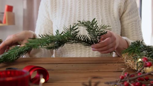 Woman Arranging Evergreen Branches for Holiday Decorations