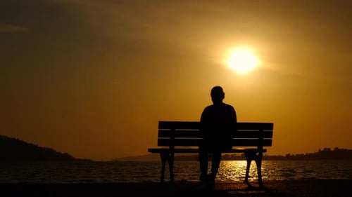 Two Silhouettes Sitting on Bench at Sunset