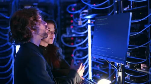 IT Professionals Coding in Data Center at Night