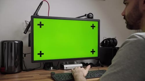 Man Works On Desktop Computer In The Home Office. Green screen. Mouse use.