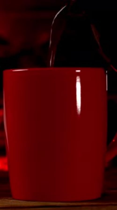 Hot Beverage Coffee or Tea Poured Into Red Cup on By Burning Fireplace