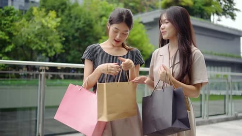 Two young woman friends are enjoying a delightful shopping experience, discussing trendy outfits