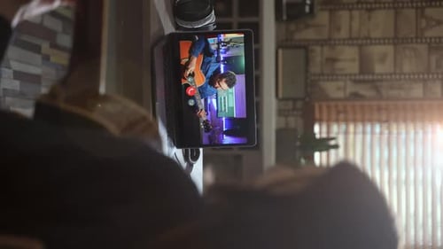 Person plays guitar using online lesson