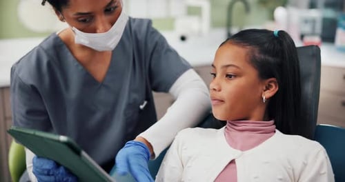 Dentist and Child Patient Looking at Tablet