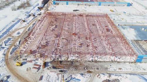 Red Metal Carcass of Warehouse Building at Snowy Site Aerial