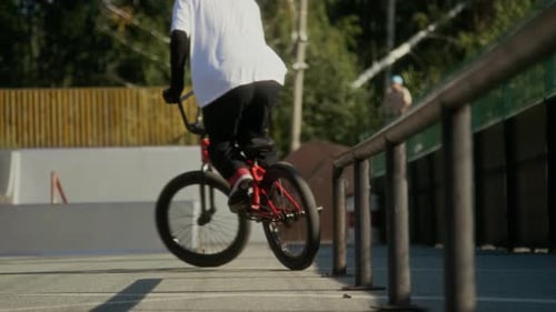 Young Athlete Learning BMX Jumps while Training at Skate Park