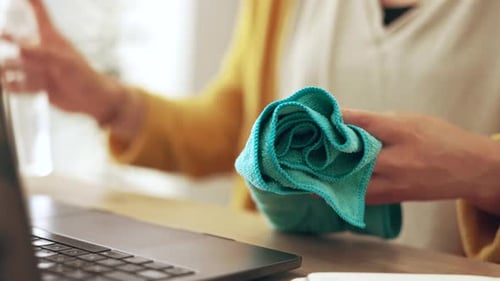 Person Cleaning Laptop with Spray and Microfiber Cloth