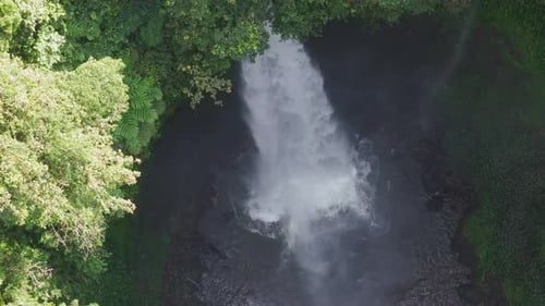 Aerial View of Thunderous Bali Waterfall Crashing Into Dark Jungle Pool