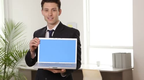 Smiling Man Holding Up Laptop with Blue Screen