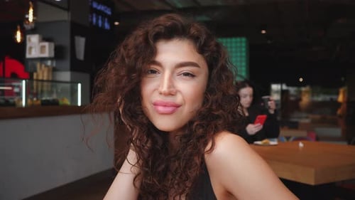 Hermoso retrato de mujer morena con cabello rizado en café