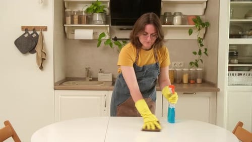 Woman Cleaning White Table in Kitchen Interior