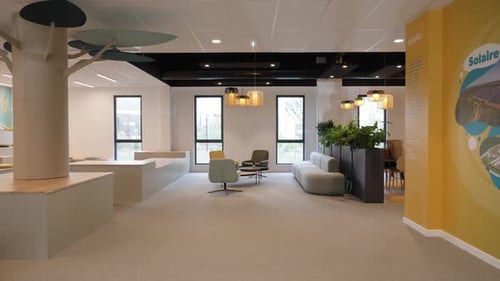 Slow revealing shot of an empty modern office with sofas and chairs
