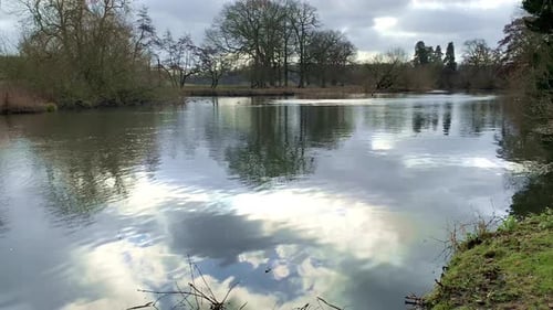 Malerischer Fluss, fließende Reflexionen am blauen Himmel, farbenfrohe Laublandschaft