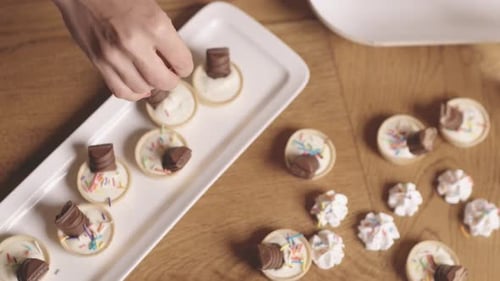op view of hand decorating mini tarts with and sprinkles