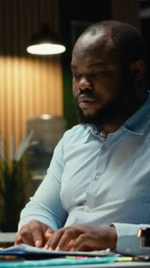 Vertical Video African American Guy Reviewing Market Data and Building Strategy