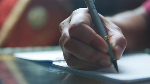 Close Up of Male Hand Writing on Paper Notebook with Fountain Pen