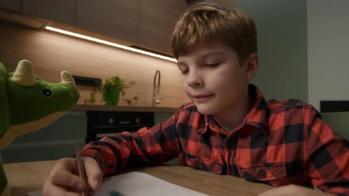 Boy Drawing Dinosaur at Table in Home