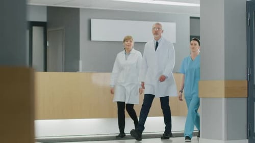 Team of Doctors, Nurses and Assistants Walking through the Lobby of the Hospital. Professional Medi