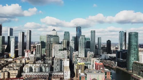 Aerial drone view of financial district in London Canary Wharf in a cloudy sunny day as the flight g