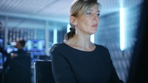 Female IT Engineer Works on Her Desktop Computer in Government Surveillance Agency. In the Backgrou