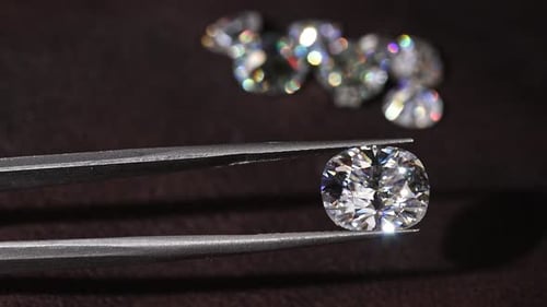 Cushion Cut Diamond Held with Tweezers Close Up