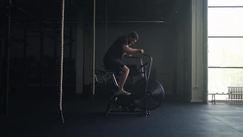 Intensive Cardio Workout Brawny Man Practicing On Stationary Bike In Gym Training In Fitness Club
