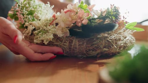 Close Up Female Hand with Red Nails Arranging Decorative Floral Wreath