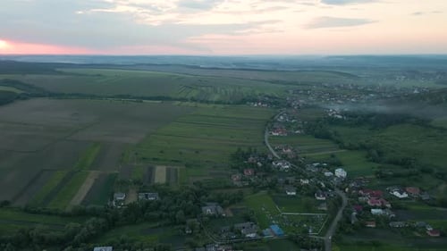 Aerial View of Green Cultivated Agricultural Fields with Growing Crops and Rural Village Houses