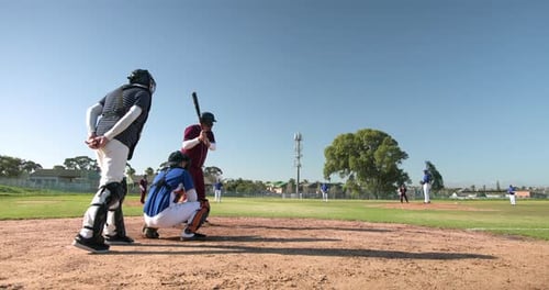 Playing baseball, catcher and batter waiting for pitch on sunny field