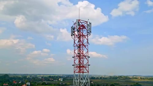 5g High Cell Tower Stands Against a Blue Sky in Rural Area Background