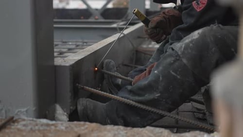 Welder at Work Sparks Fly on Construction Site