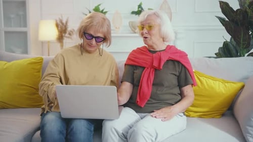 Senior Women Using a Laptop on Couch Indoors