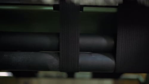 Black Webbing Moving Over Rollers Textured Woven Strap Advancing Under Tension Control Rubberized