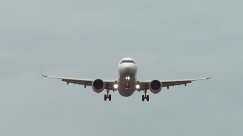 Passenger Plane Approaching for Landing in Cloudy Sky Aircraft Descending with Landing Gear Deployed