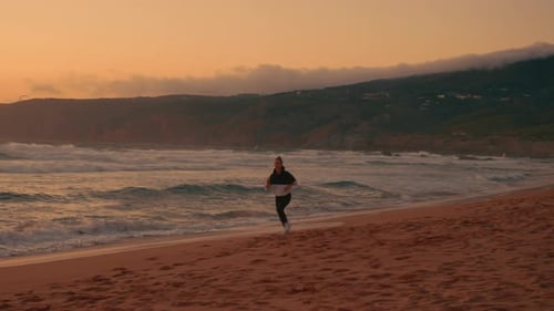 Determined Jogger Woman Running on Scenic Shore During Sunset at Beach