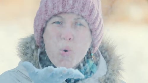 Woman Blowing Snow in Winter Wonderland Outdoors
