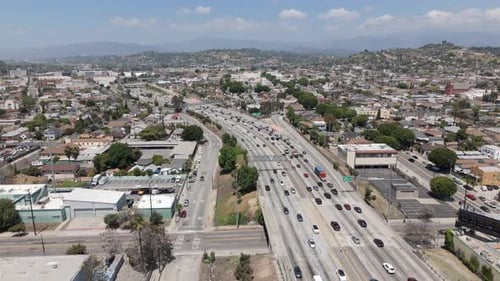 Vehicles Driving On The 5 Freeway In Los Angeles, Californian Hills In Background. Rising Drone Shot