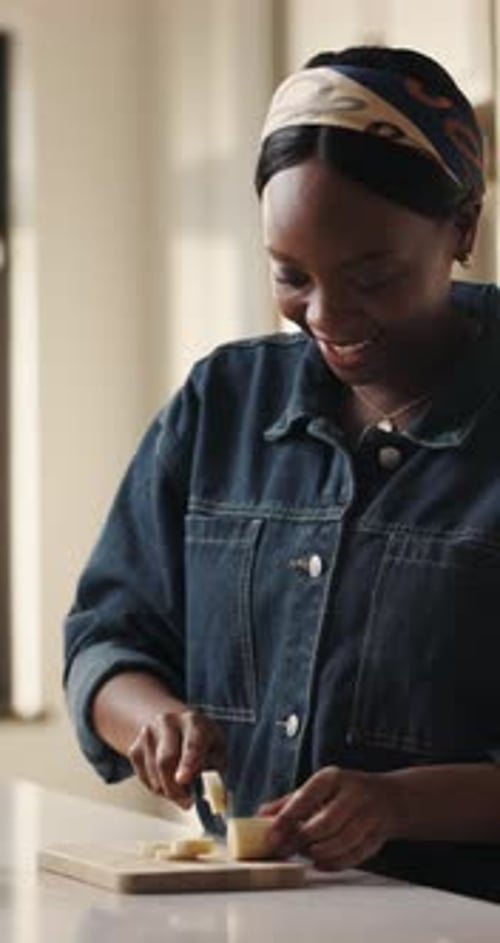 Woman Cutting Cheese with Knife on Cutting Board