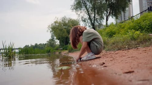 a child without adult supervision plays near the water danger lack of care loneliness