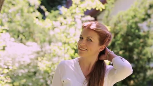 Smiling woman in white shirt outdoors in garden