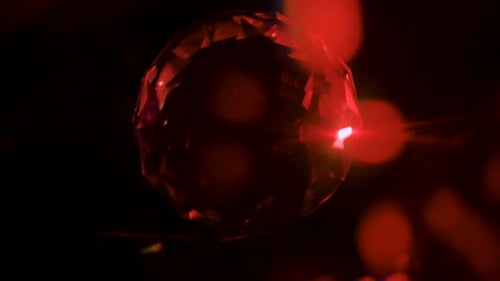 Rotes Makro-Licht im Kinostil beleuchtet facettierten Kristall-Edelstein