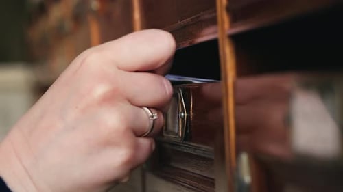 A Postman Places Letters in Mailboxes in the Entrance of a Dilapidated Apartment Building