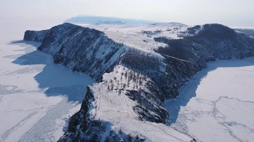Drone Captures Snowcapped Mountain Ridge Frozen Lake Showcasing Beautiful Arctic Landscape