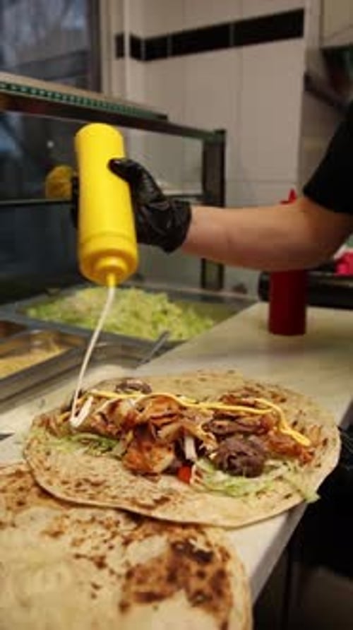 Preparing a Kebab Wrap with Sauce in Restaurant